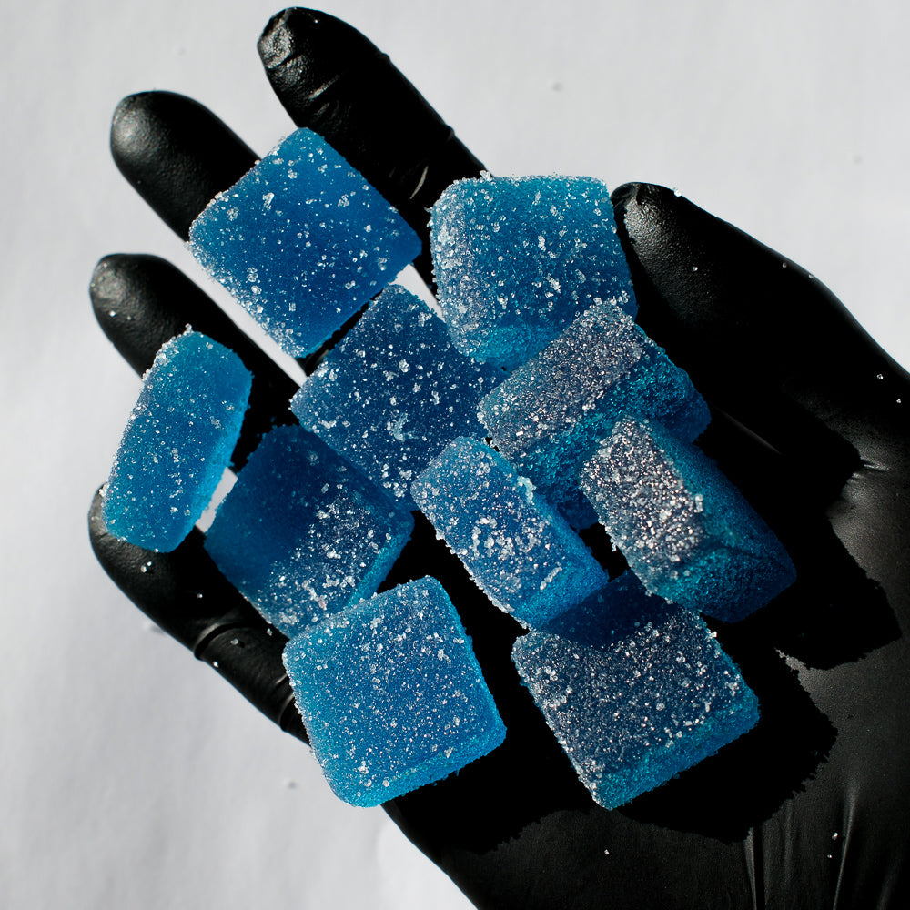 Tas de gummies bleus tenus dans une main